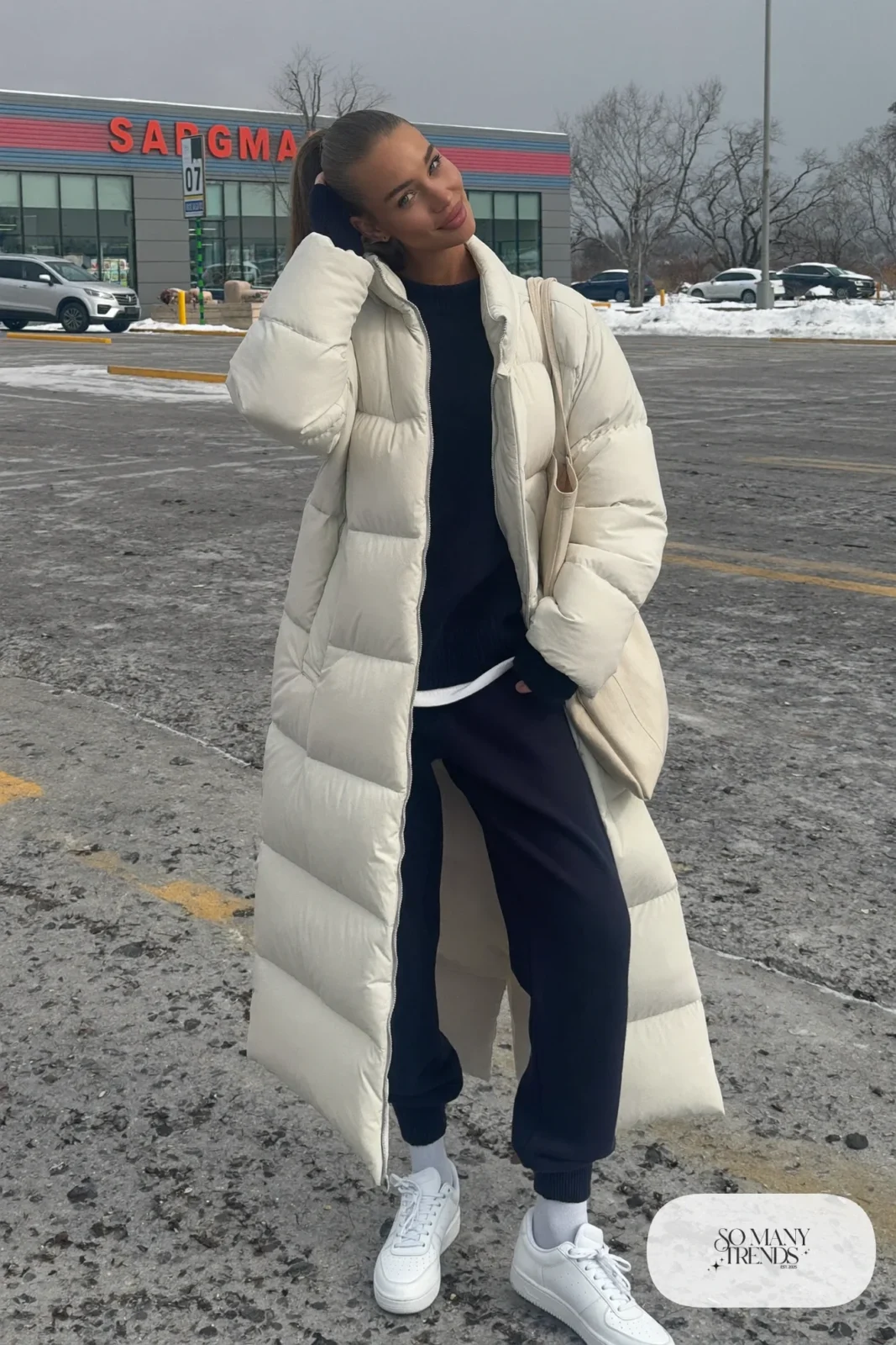 Look 32: long cream puffer coat, navy knit sweater, navy tapered joggers and white leather sneakers
