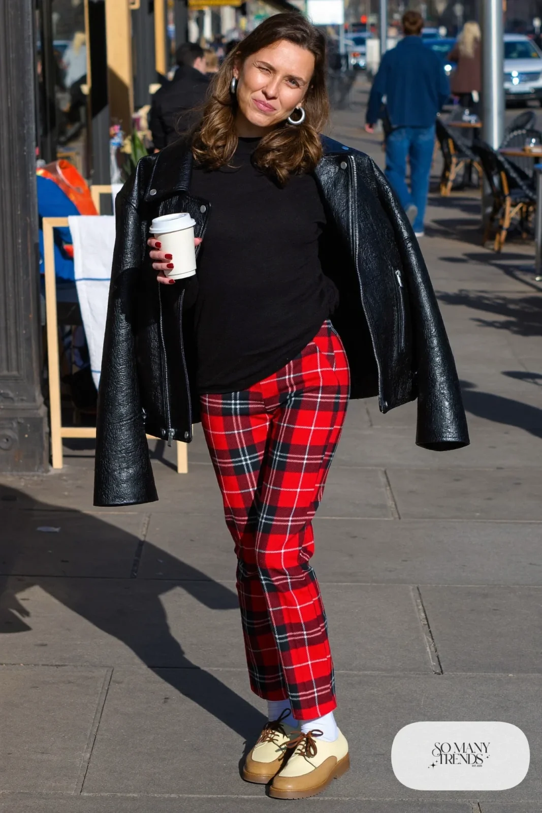Woman in red-and-black tartan pants, white socks, two-tone derby heels, black sweater and leather jacket, outfit 8