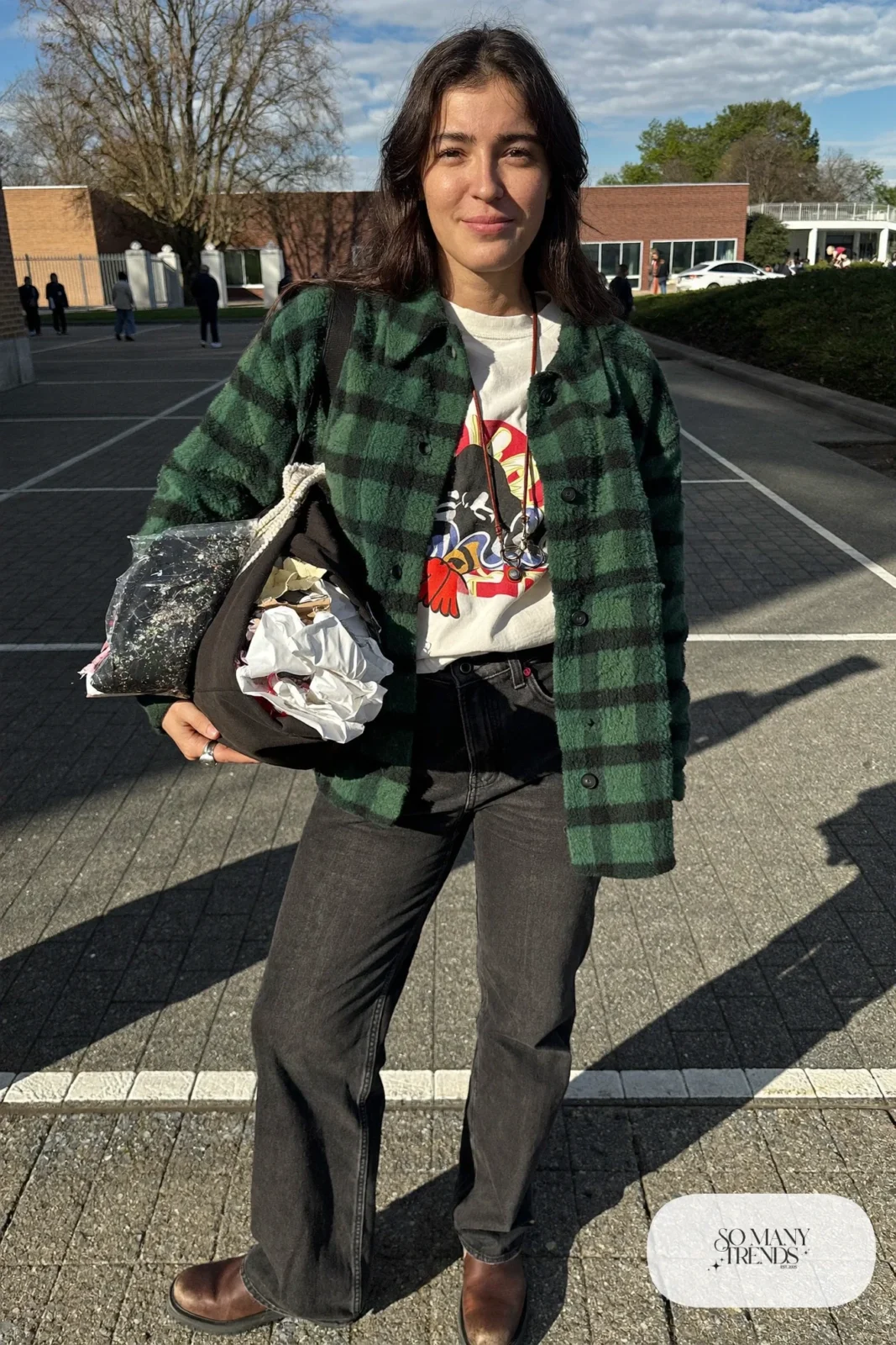 Woman in a forest green plaid shacket, white graphic tee, black straight jeans and brown lug-sole boots, outfit 9