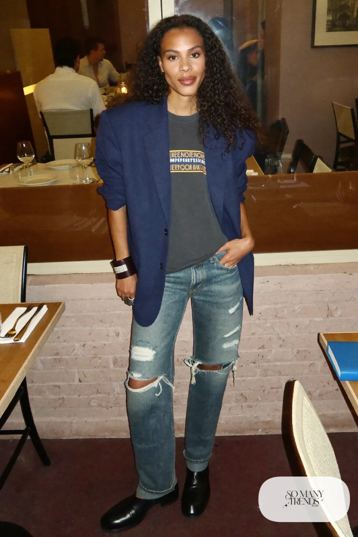 Woman in a navy oversized blazer, faded band tee, ripped jeans and black Chelsea boots, outfit 33