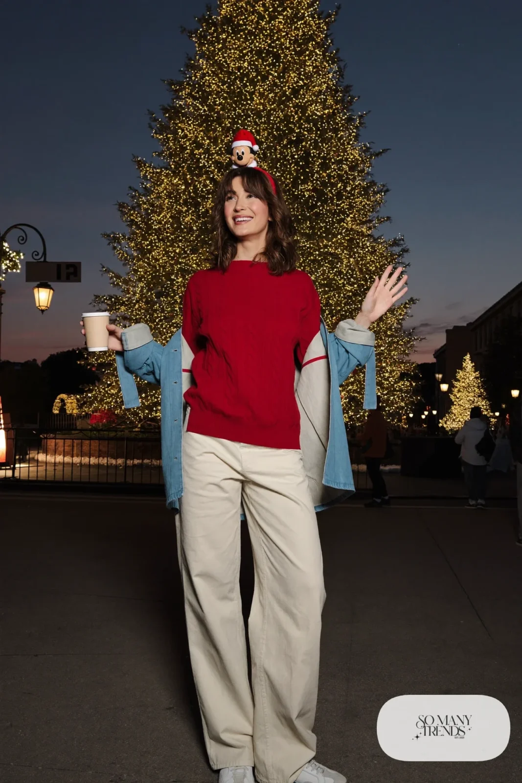 Holly red cable-knit sweater with cream wide-leg pants, indigo light coat and white sneakers, outfit 27