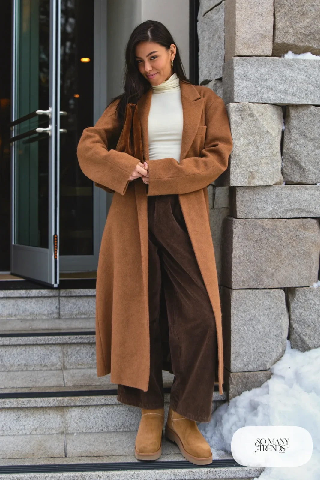 Woman in a long camel cashmere cardigan coat, cream turtleneck, brown corduroy pants and tan leather boots, outfit 11