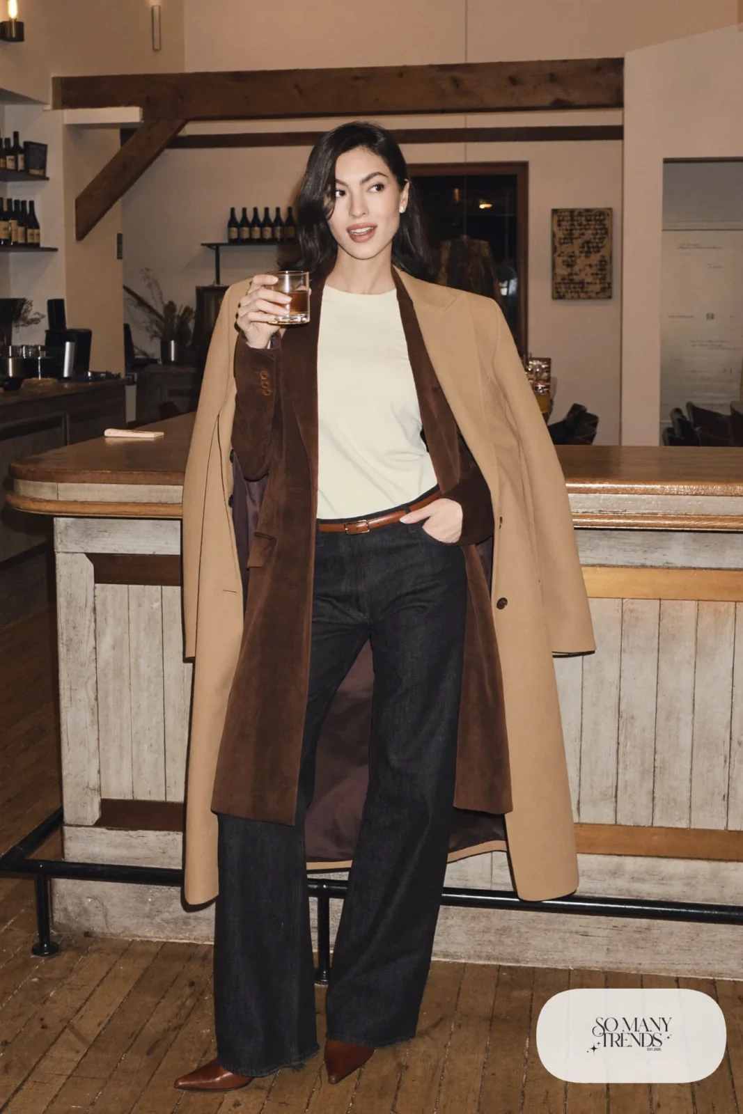 Woman in a brown suede blazer, cream knit top, dark straight jeans and pointed cognac boots, outfit 21