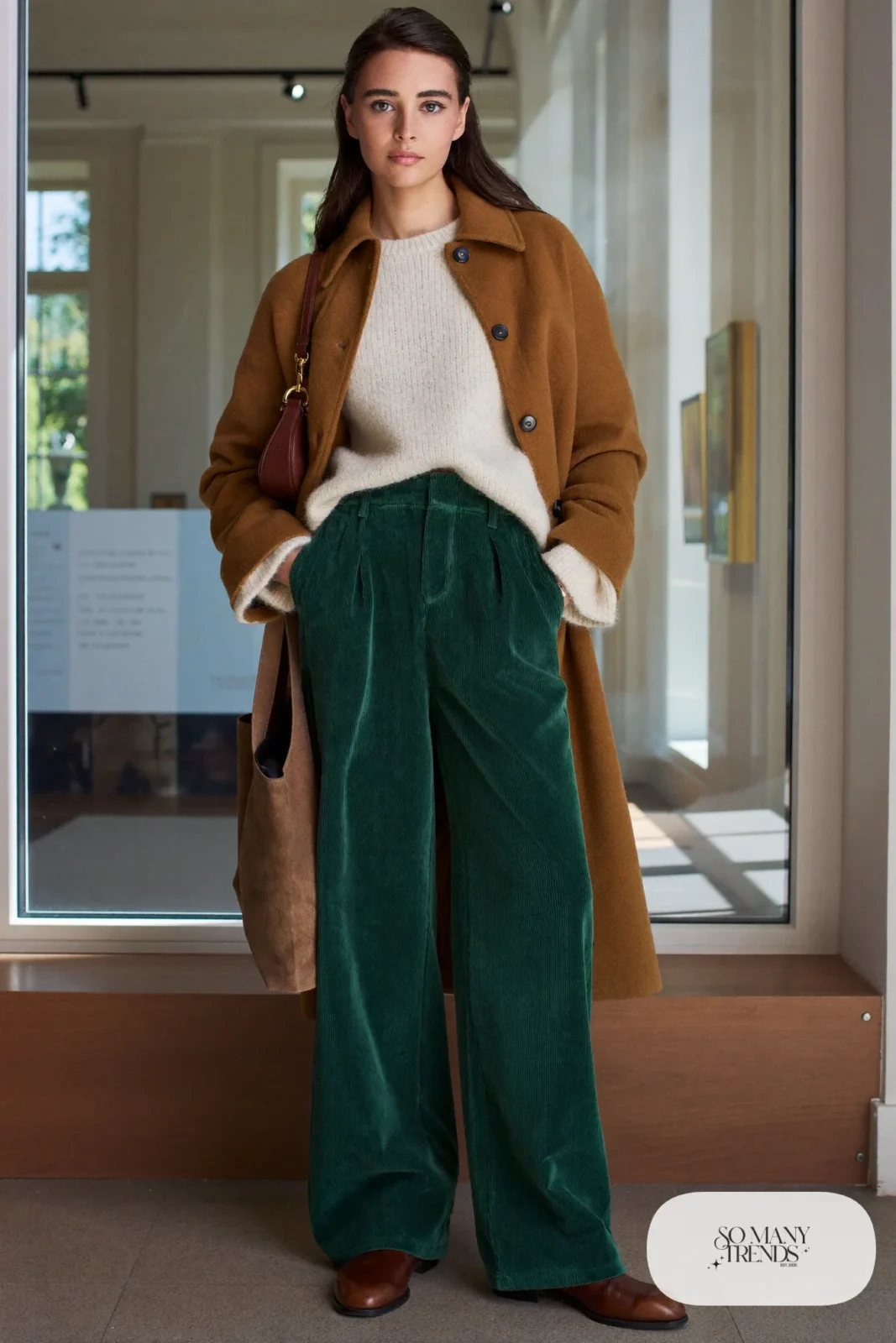 Woman in forest green wide-leg corduroy pants, ivory chunky sweater, camel wool coat and brown leather boots, outfit 4