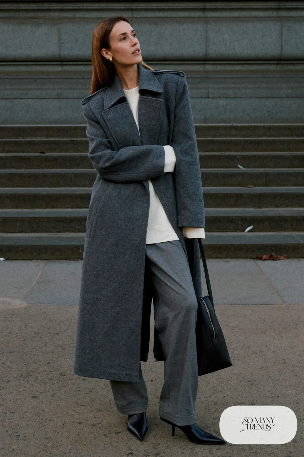 Woman in a charcoal wool overcoat, ivory knit sweater, gray flannel wide-leg pants and black leather boots, outfit 8