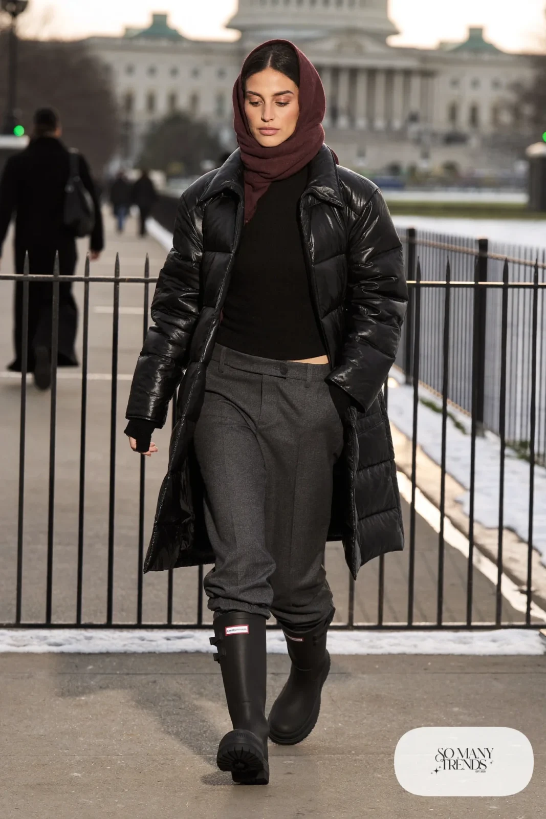 Woman in black waterproof leather boots, gray wool pants, black puffer-style coat and a wool scarf, outfit 13