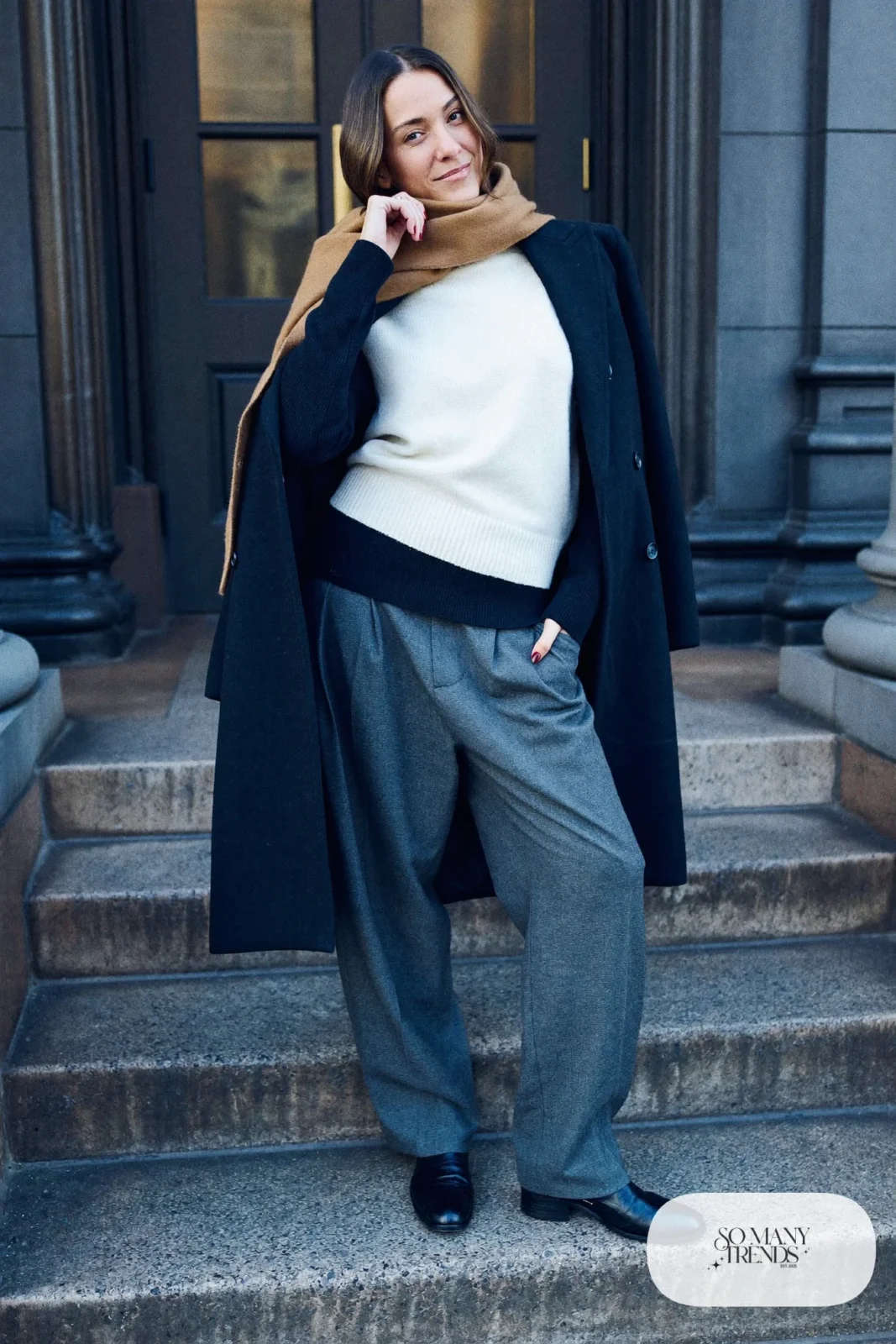 Woman in a black merino base layer under an ivory sweater, gray wool pants, charcoal coat and black boots, outfit 15