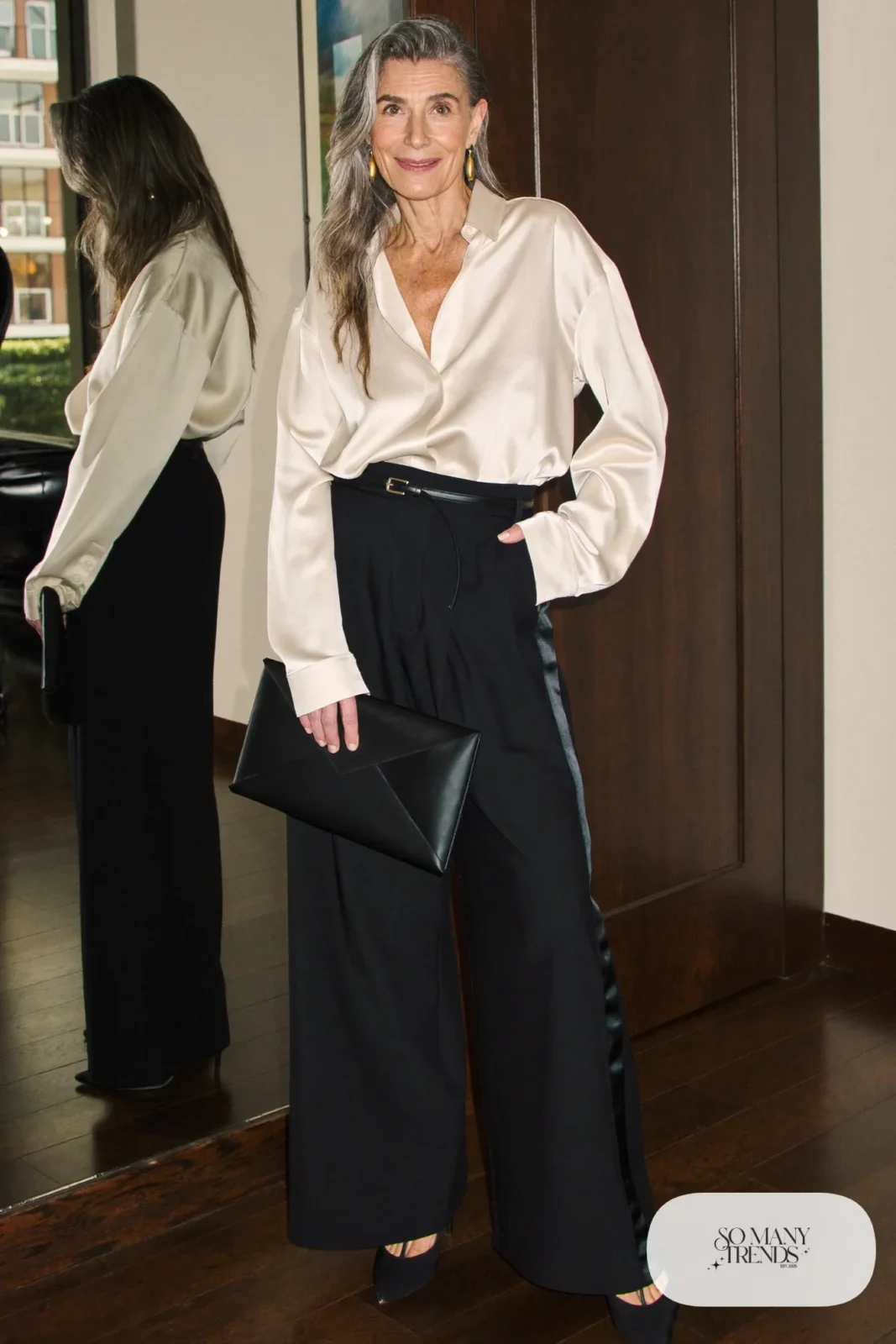 Woman in a cream satin blouse, black wide-leg tuxedo pants with a satin stripe, thin belt and black pumps, outfit 13