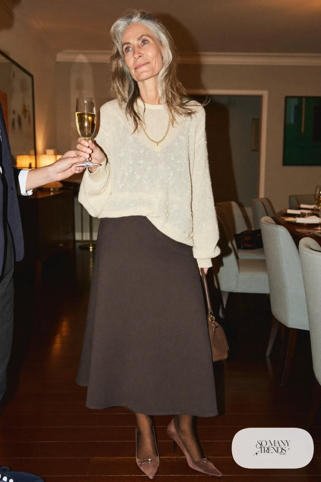 Woman in a cream shimmer knit sweater, chocolate brown midi skirt, sheer tights and brown suede pumps, outfit 28