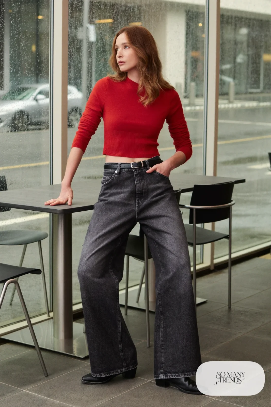 Woman in washed charcoal wide-leg jeans, tomato red fitted knit sweater and black leather boots, outfit 2