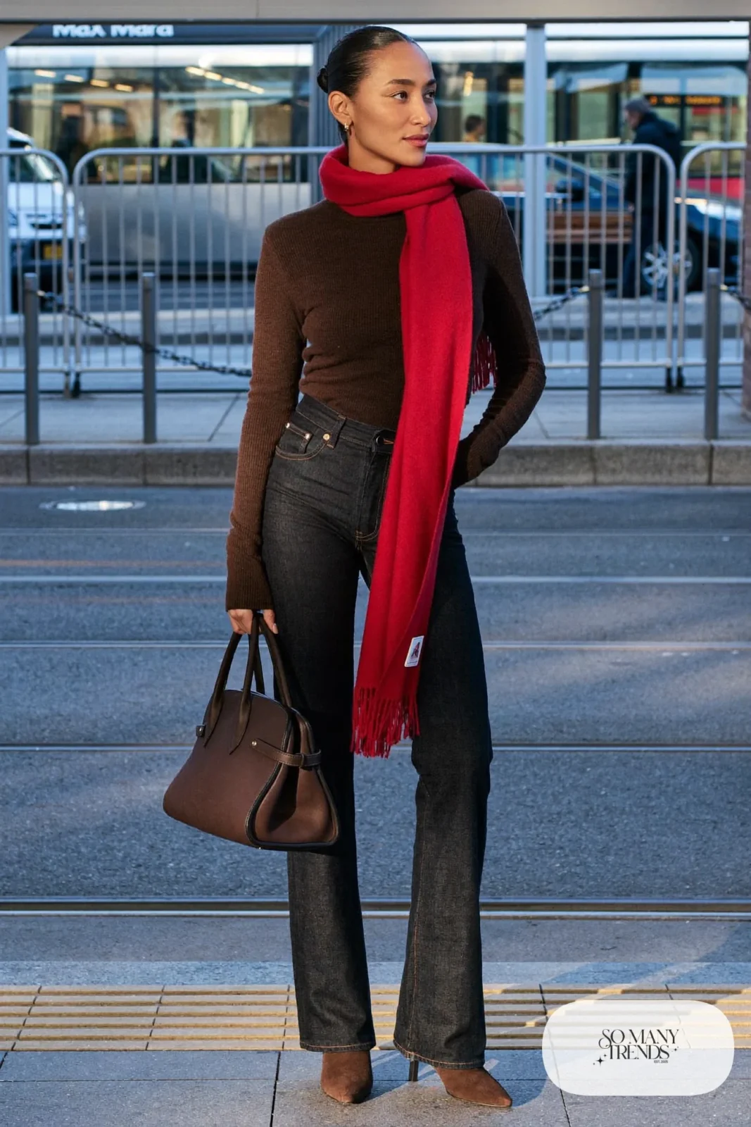 Woman in dark bootcut jeans, chocolate brown knit sweater, red scarf and brown suede boots, outfit 5