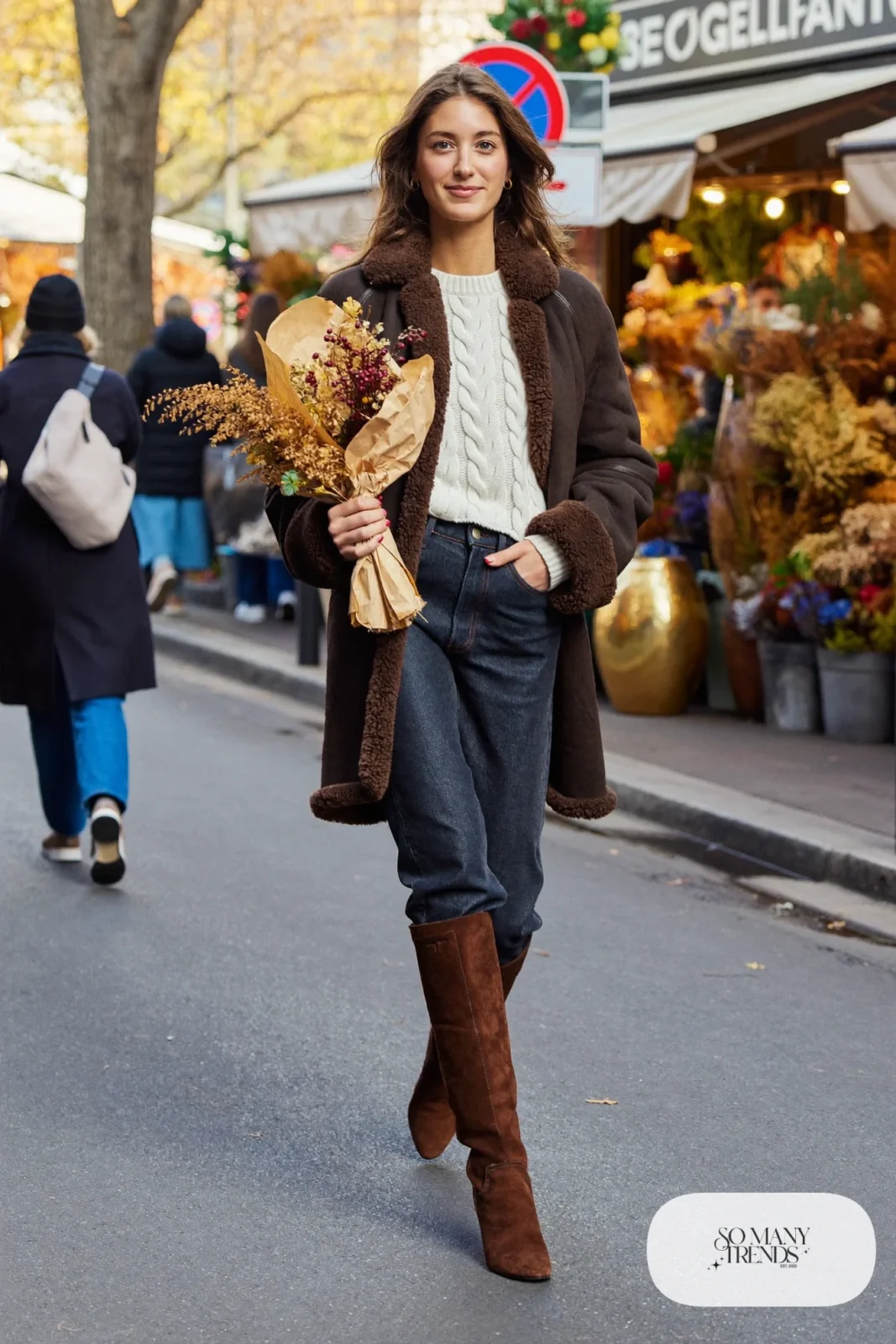 Woman in shearling-style jacket, cream knit sweater, dark jeans and chocolate boots, outfit 10