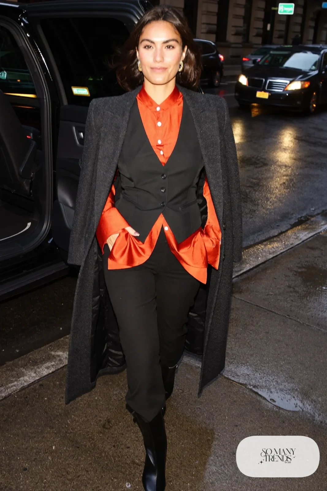 Woman in black tailored vest, tomato red silky shirt, black pants and black pointed boots, outfit 25