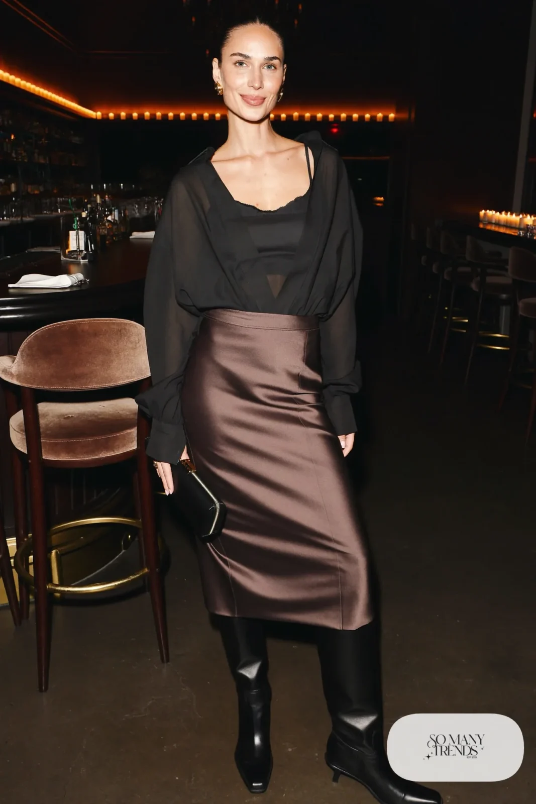 Woman in a black sheer blouse over a camisole with an espresso satin long skirt and tall black boots, photo 23