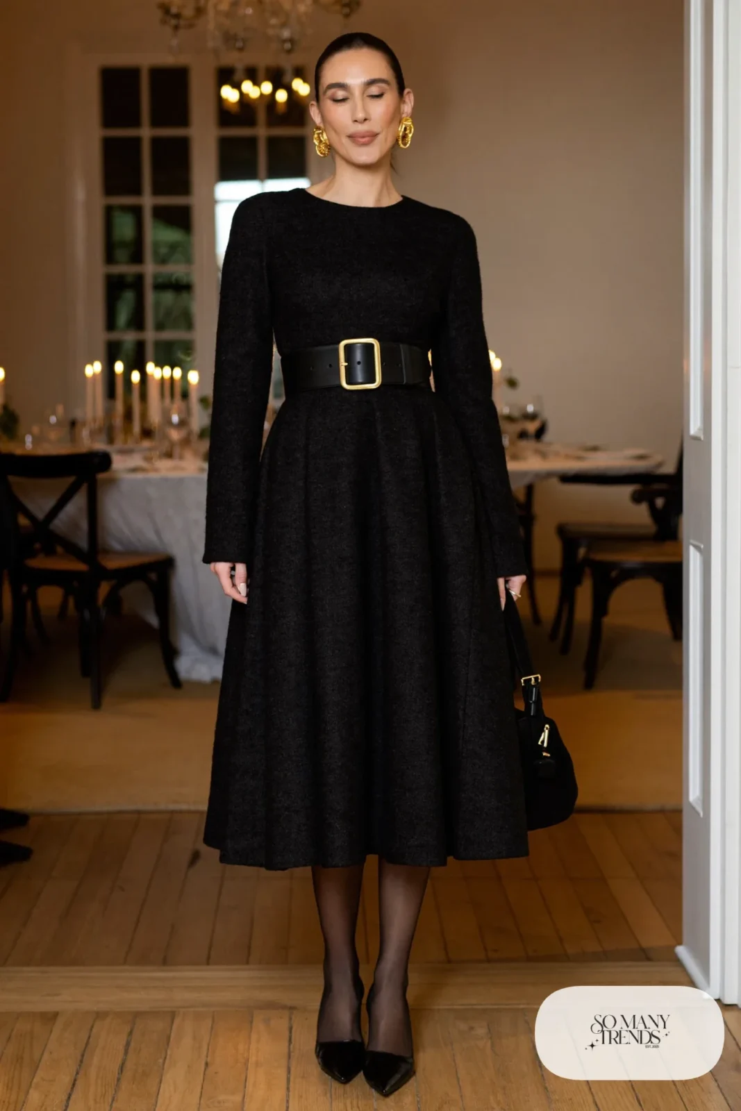 Woman in a black long-sleeve wool fit-and-flare dress with a wide gold-buckle belt and black pumps, photo 24