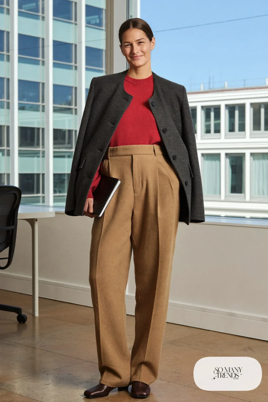 Woman in camel pleated trousers, tomato red knit, black belt and brown ankle boots, outfit 19