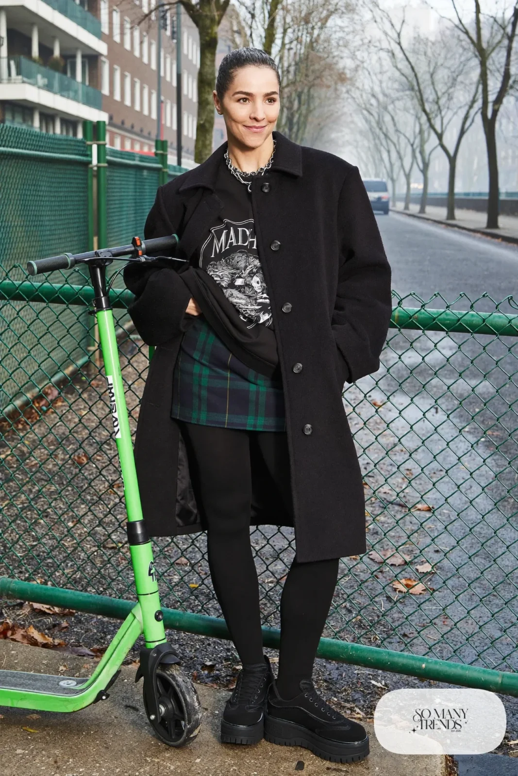 Woman in a navy plaid mini skirt, opaque black tights, black graphic sweatshirt and platform sneakers, outfit 11