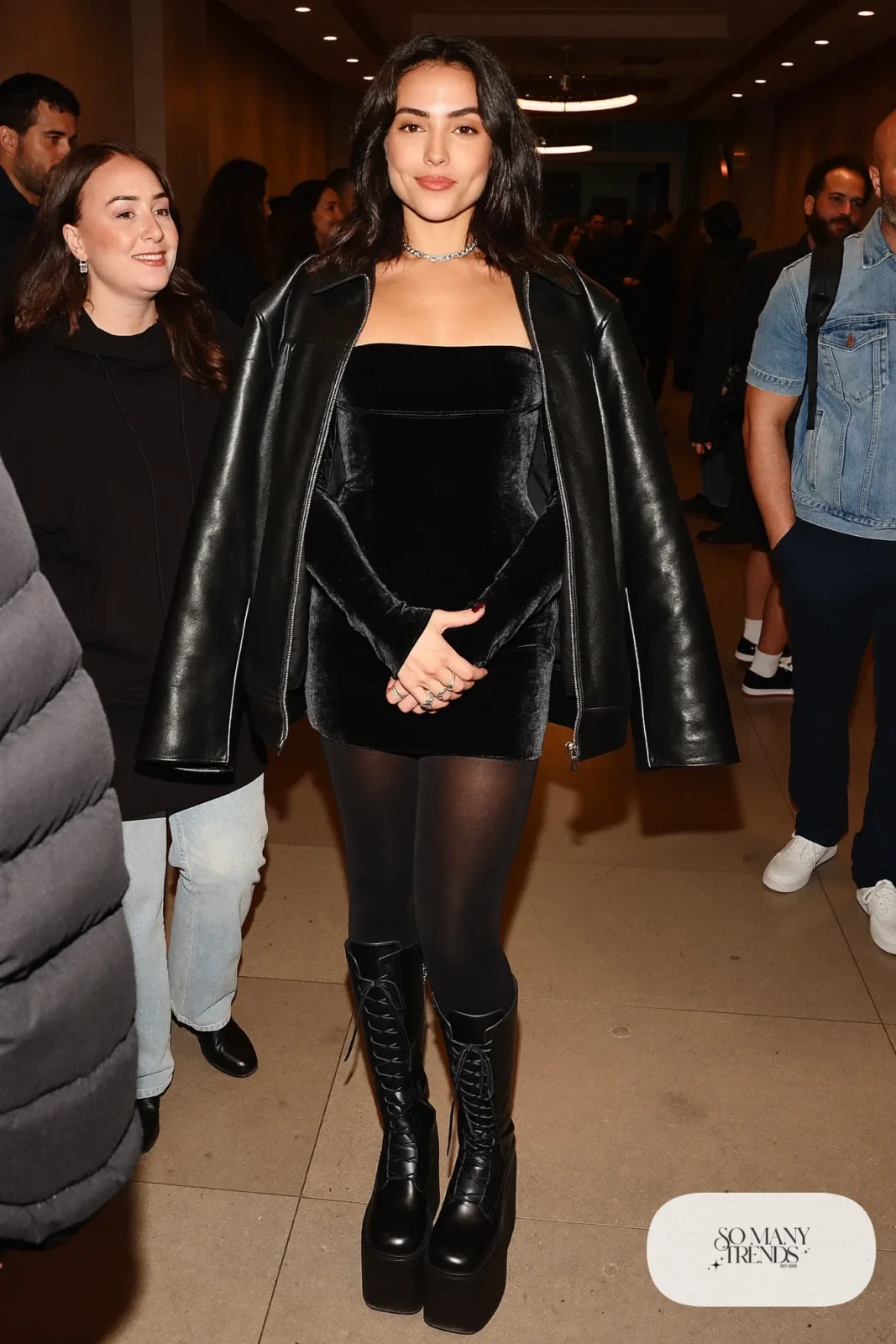Woman in a black velvet long sleeve mini dress, oversized leather jacket, thick tights and platform boots, outfit 17