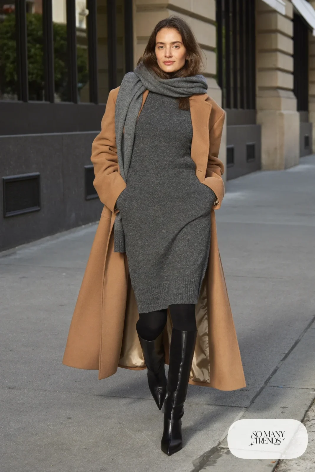 Woman in a charcoal sweater midi dress with a belt, tall black boots, tights and a camel coat, outfit 29