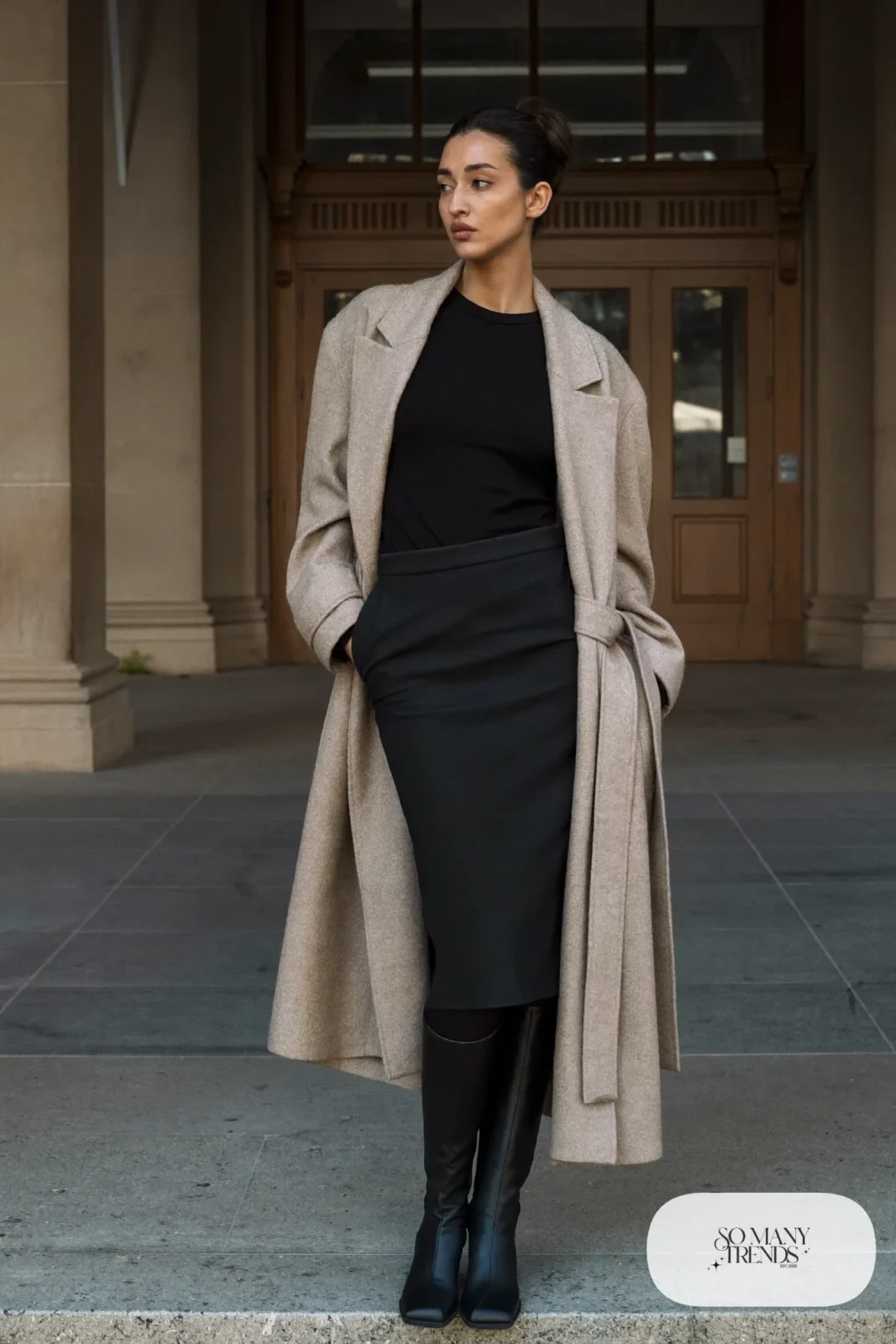 Long champagne belted cardigan coat over black column midi skirt and fitted knit with black boots, outfit 11