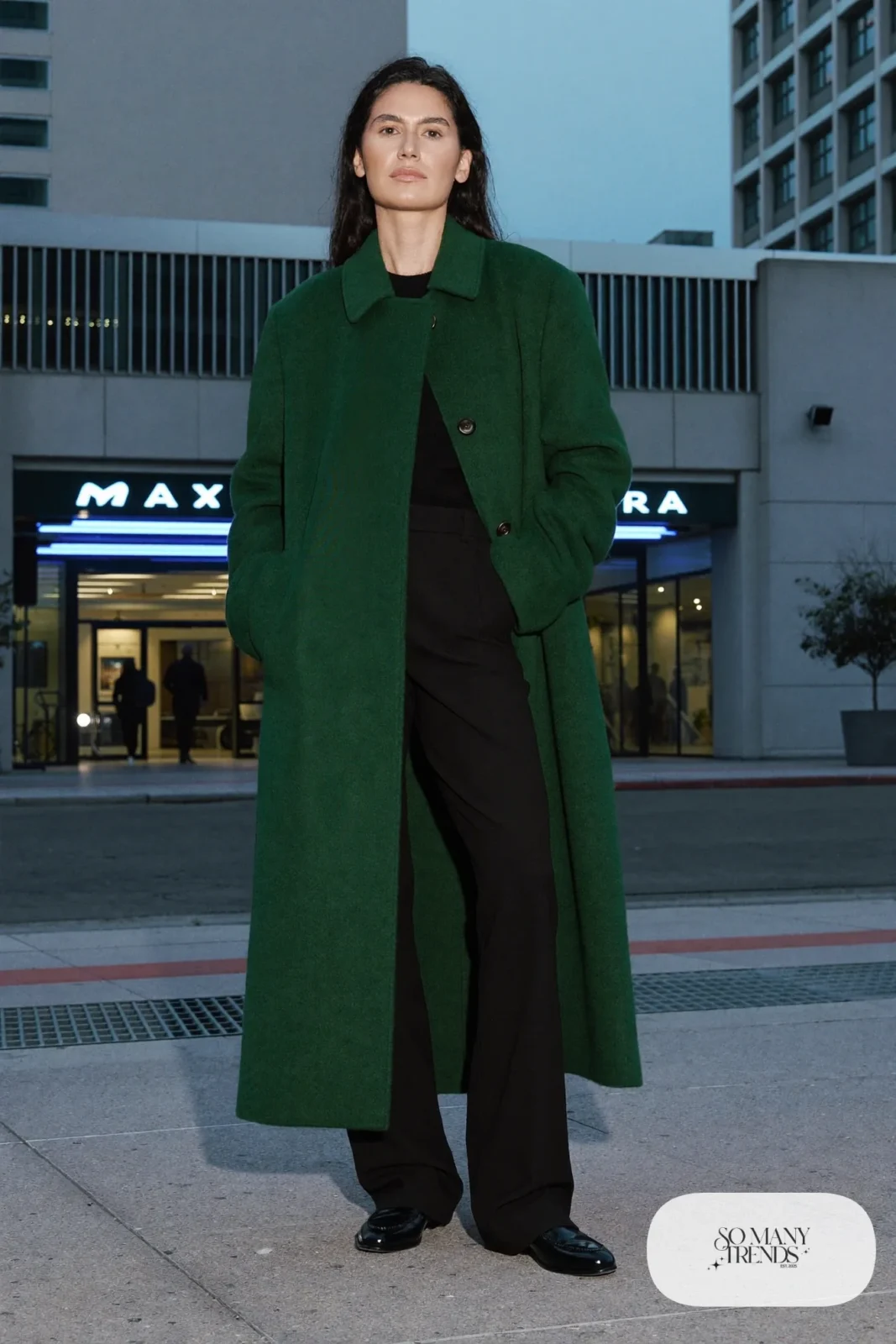 Long forest green wool-blend coat over black knit and wide-leg pants with black loafers, outfit 23