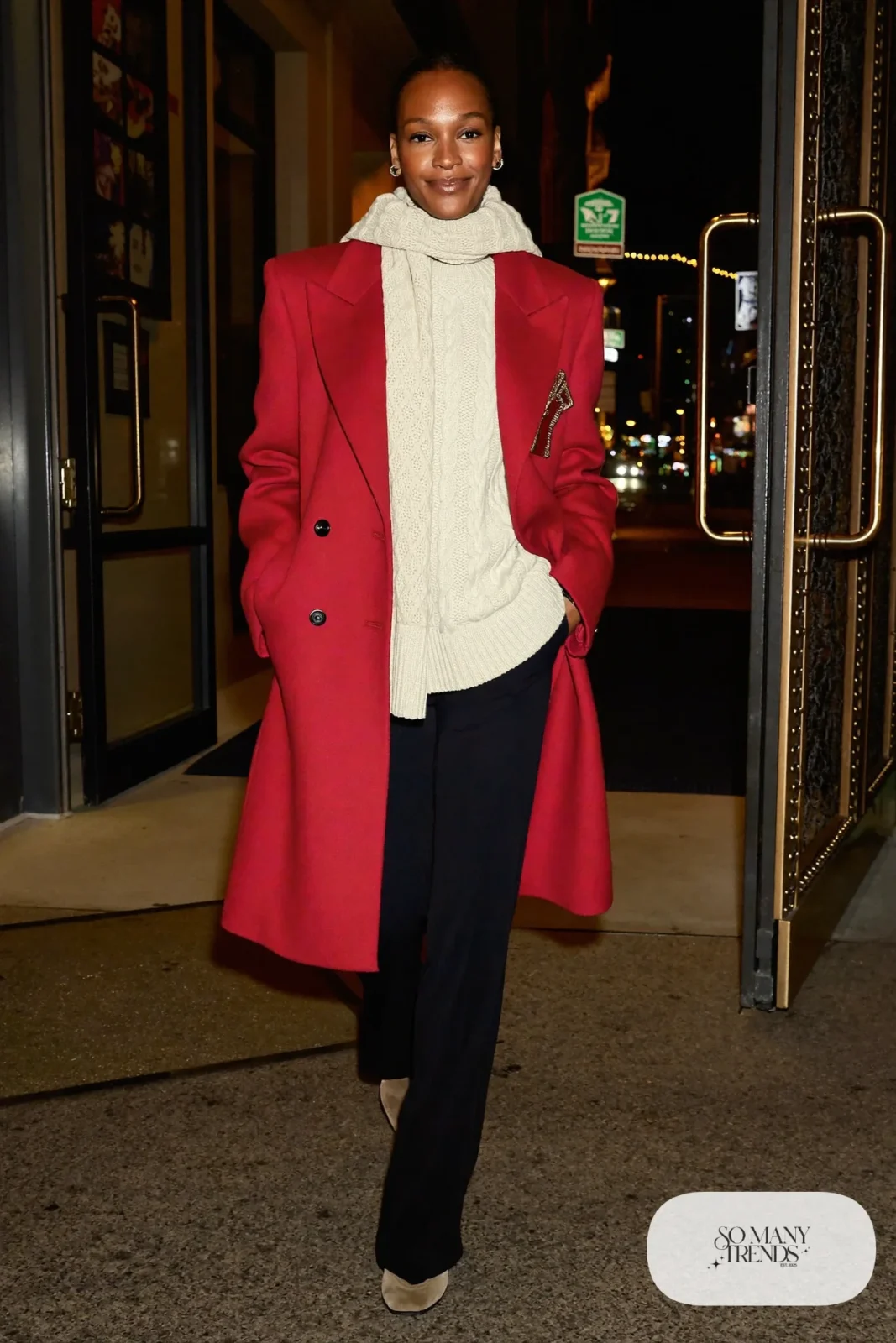 Long cranberry wool coat over cream cable-knit sweater, black wide-leg pants and taupe suede ankle boots, outfit 1