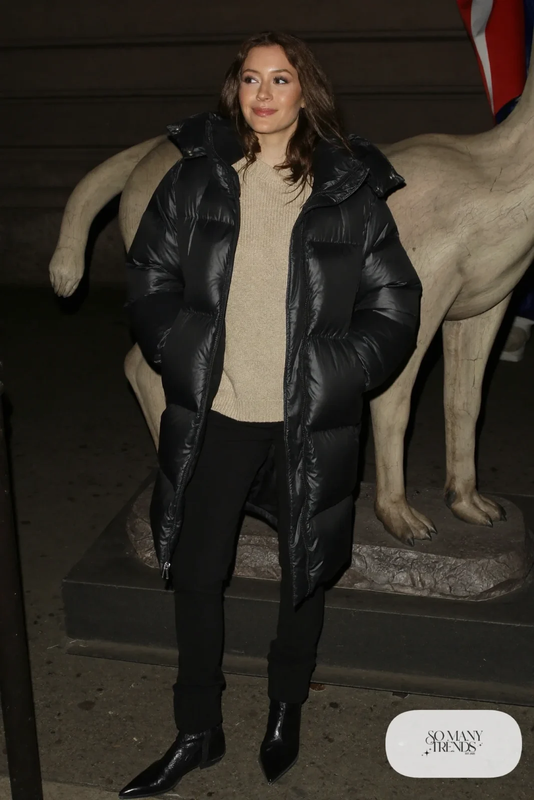 Long black puffer coat over champagne ribbed knit sweater, black pants and black ankle boots, outfit 5