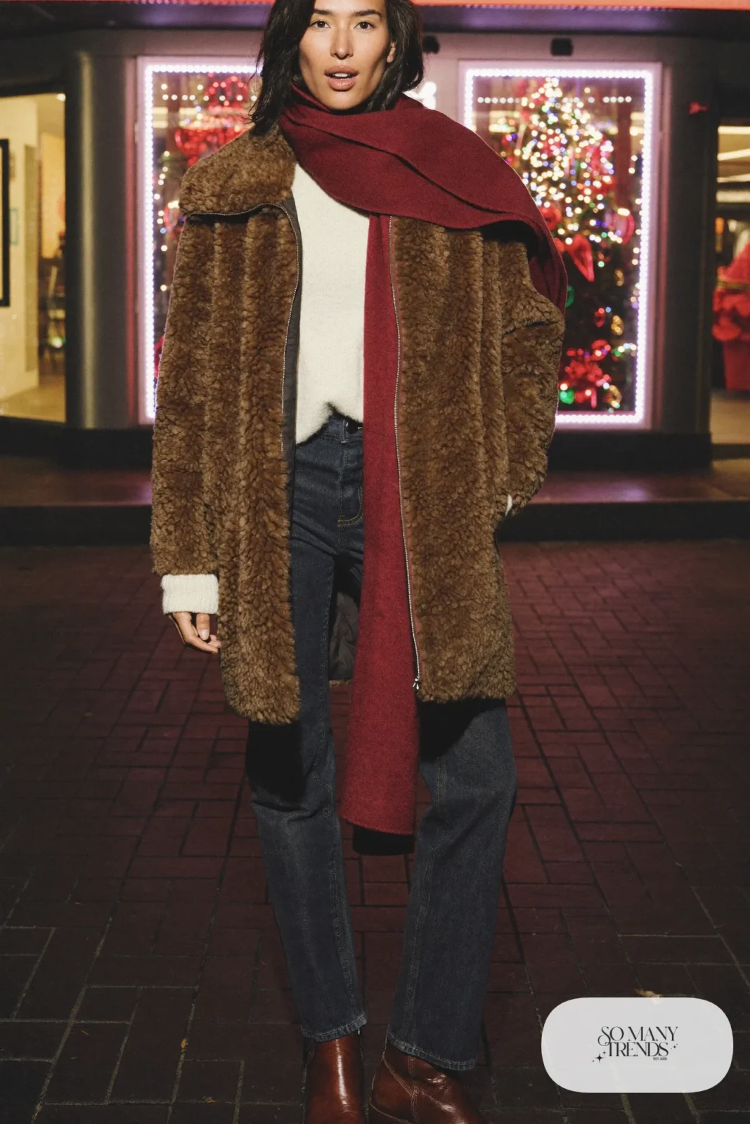 Brown faux shearling jacket with cranberry scarf, cream sweater, dark jeans and brown boots, outfit 6