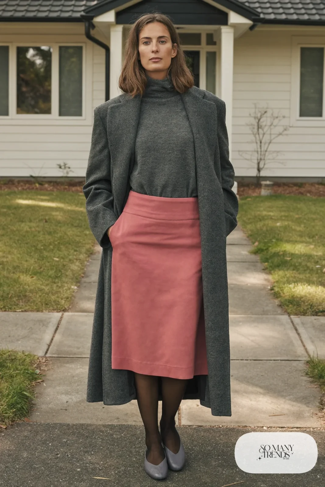 Woman in a gray fine-knit mock-neck sweater tucked into a dusty pink crepe midi skirt, sheer black tights and gray closed-toe block heels, outfit 9