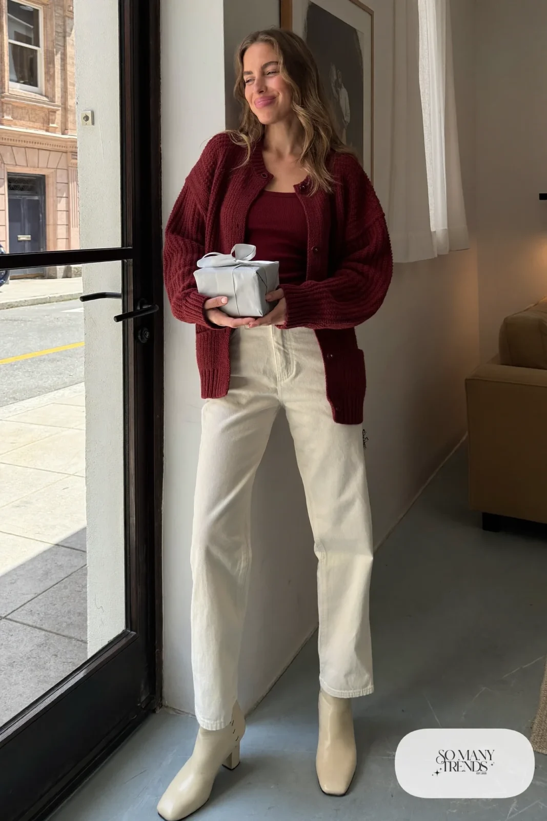 Woman in a burgundy knit cardigan and tank set, cream straight-leg twill pants and cream ankle boots, outfit 19