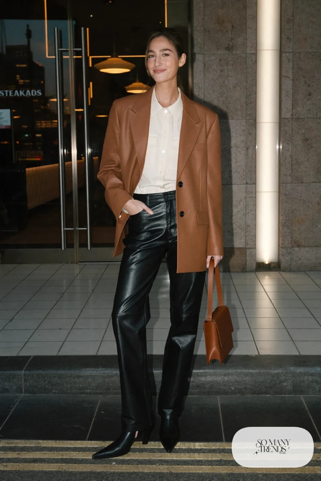 Woman in black leather straight pants, cream blouse, camel blazer and ankle boots at a Las Vegas steakhouse, outfit 14