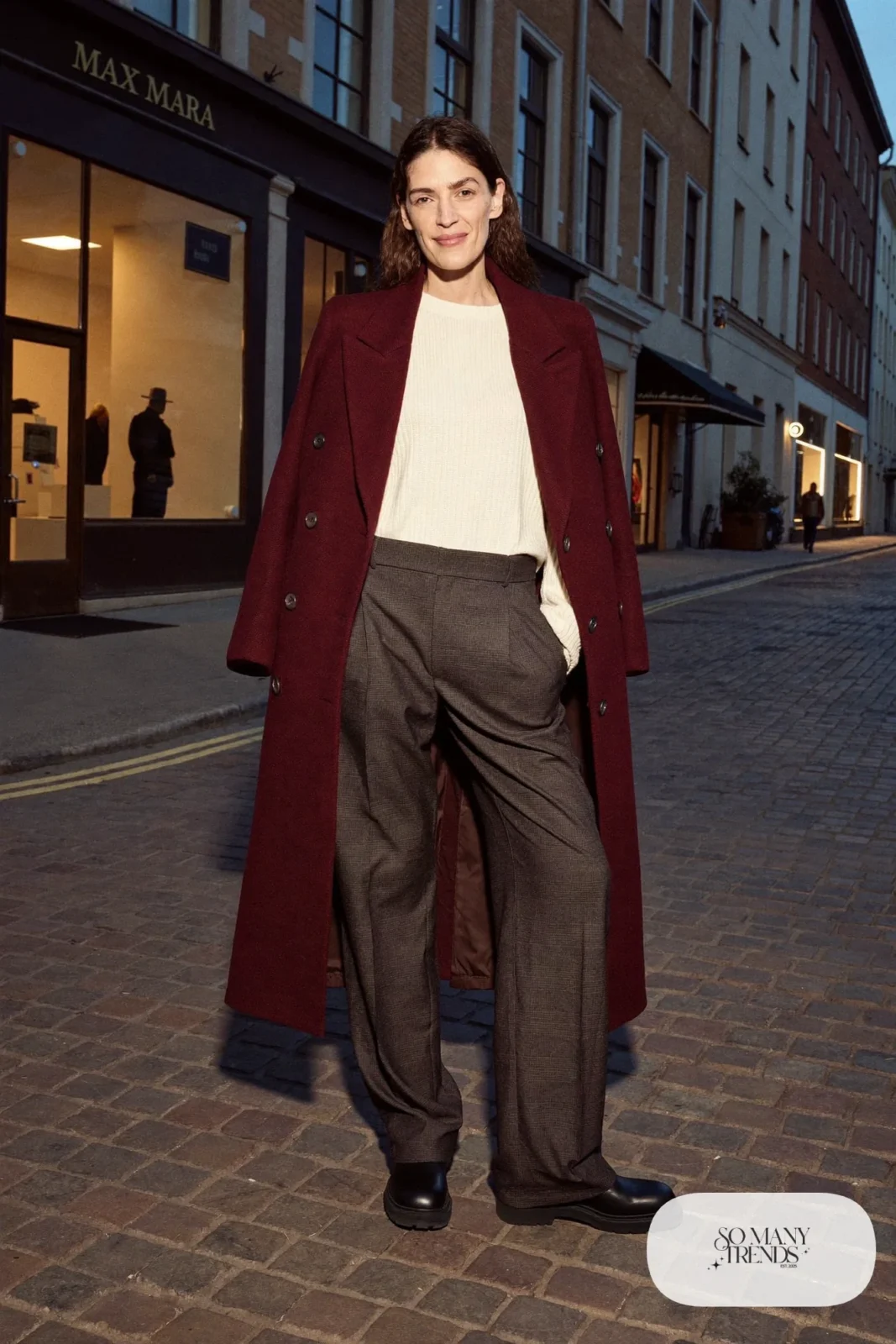 Burgundy wool coat, cream knit sweater tucked into charcoal pleated wool pants and black grippy ankle boots, Prague winter outfit 15