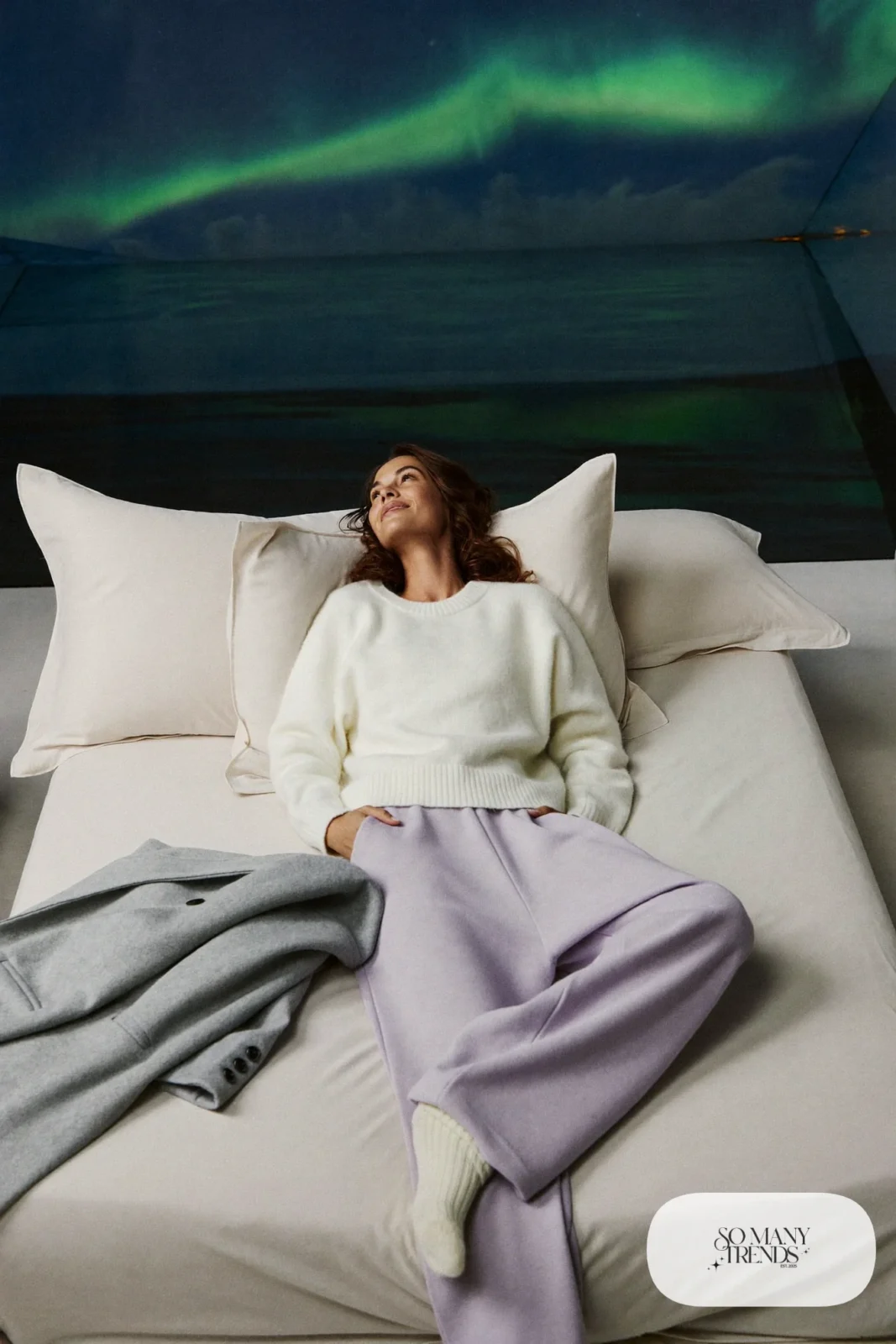 White cashmere sweater with lilac lounge pants and thick socks in glass igloo at night, outfit 19