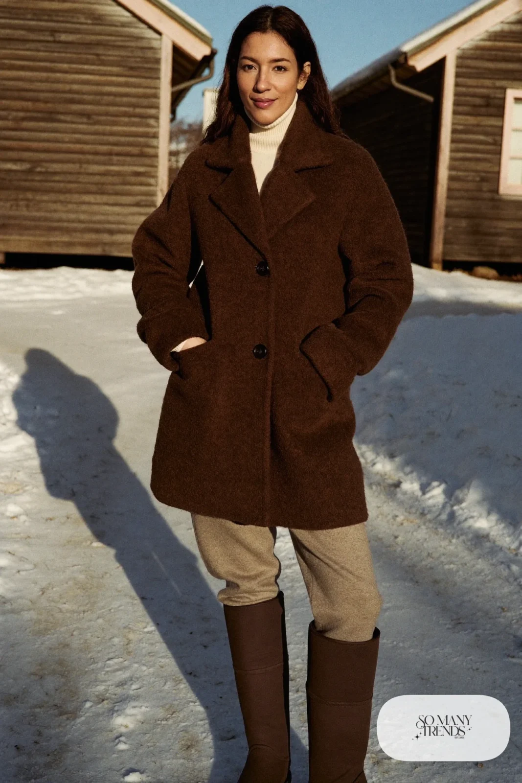 Brown wool cardigan coat over cream turtleneck with leggings and boots on cabin path, outfit 20