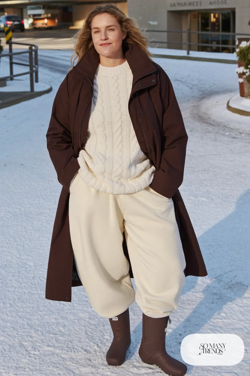 Look 12: chocolate anorak over a cream knit sweater and wide cream fleece pants with brown boots, snowshoeing trail