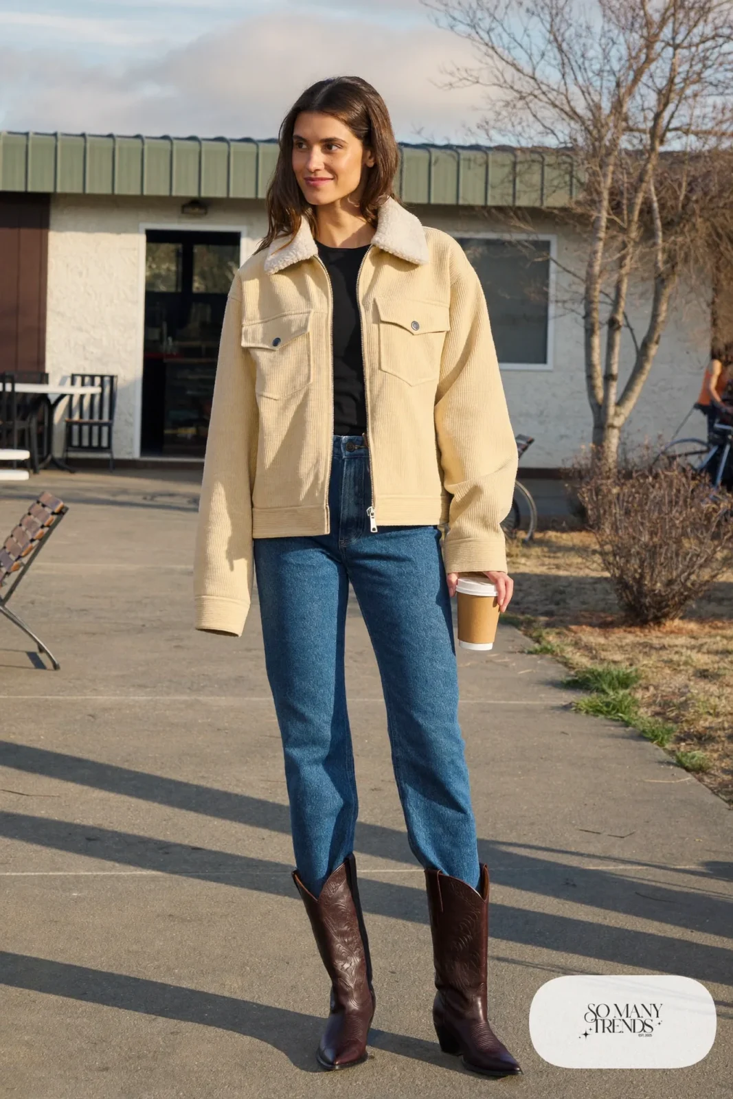 Woman in a champagne corduroy trucker jacket with shearling lining, black tee, blue jeans and brown boots, outfit 4