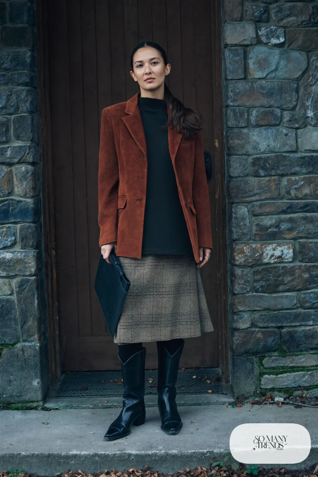 Woman in a tweed skirt, rust suede blazer, black tights and black western boots, outfit 10
