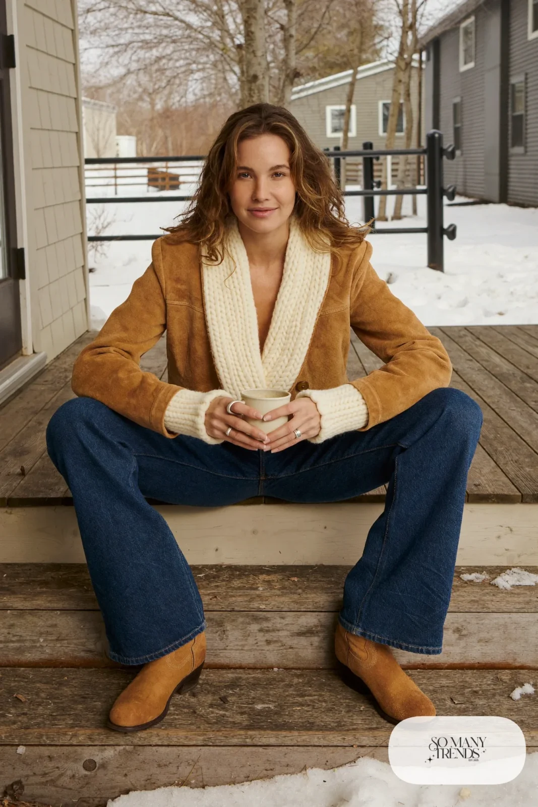 Woman in a chunky cream cardigan, suede jacket, dark jeans and short western boots, outfit 19