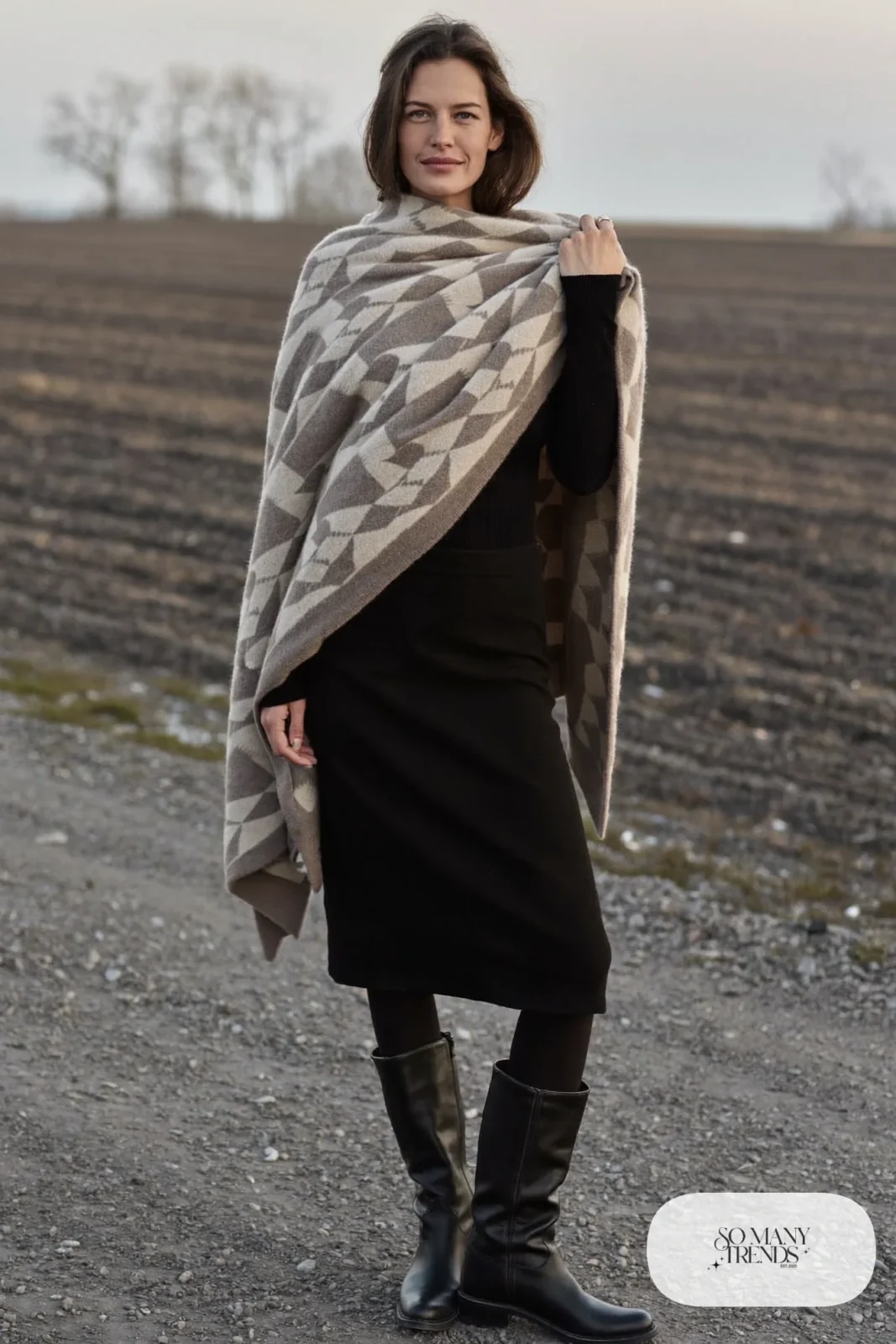 Woman in a taupe poncho, black slim skirt and tall black boots, outfit 20