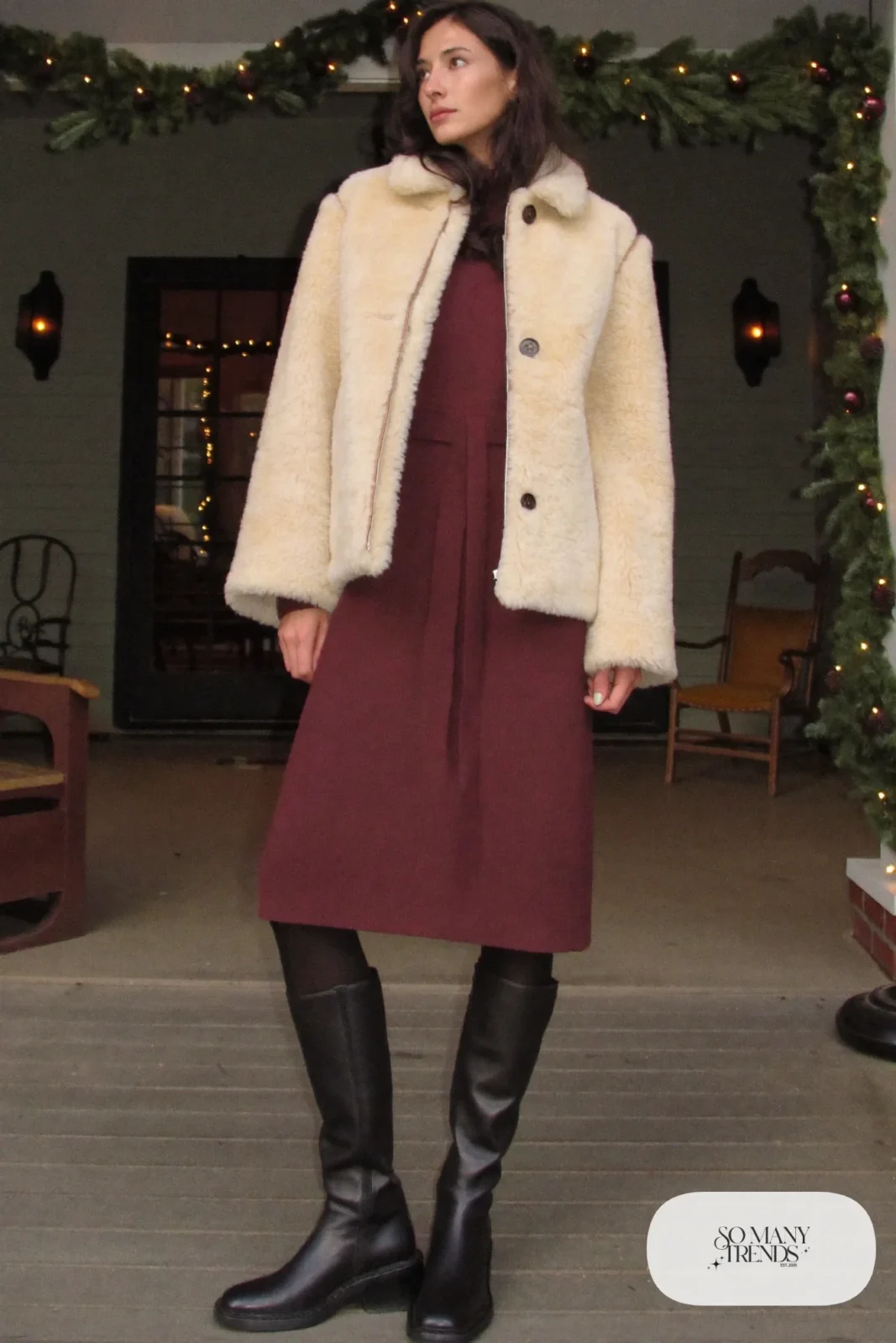 Woman in a cranberry knit midi dress, shearling jacket, black tights and tall black boots, outfit 29