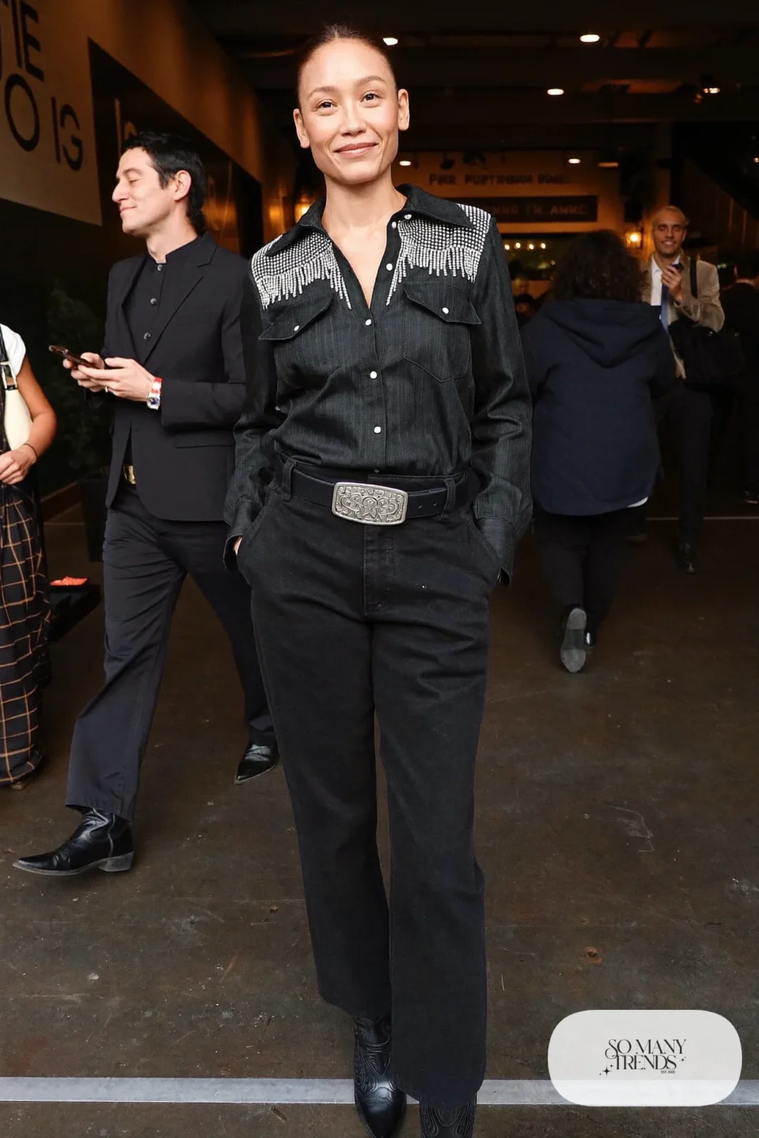 Woman in black rhinestone western snap shirt, black high-waist pants, silver buckle belt and black cowboy boots, outfit 8
