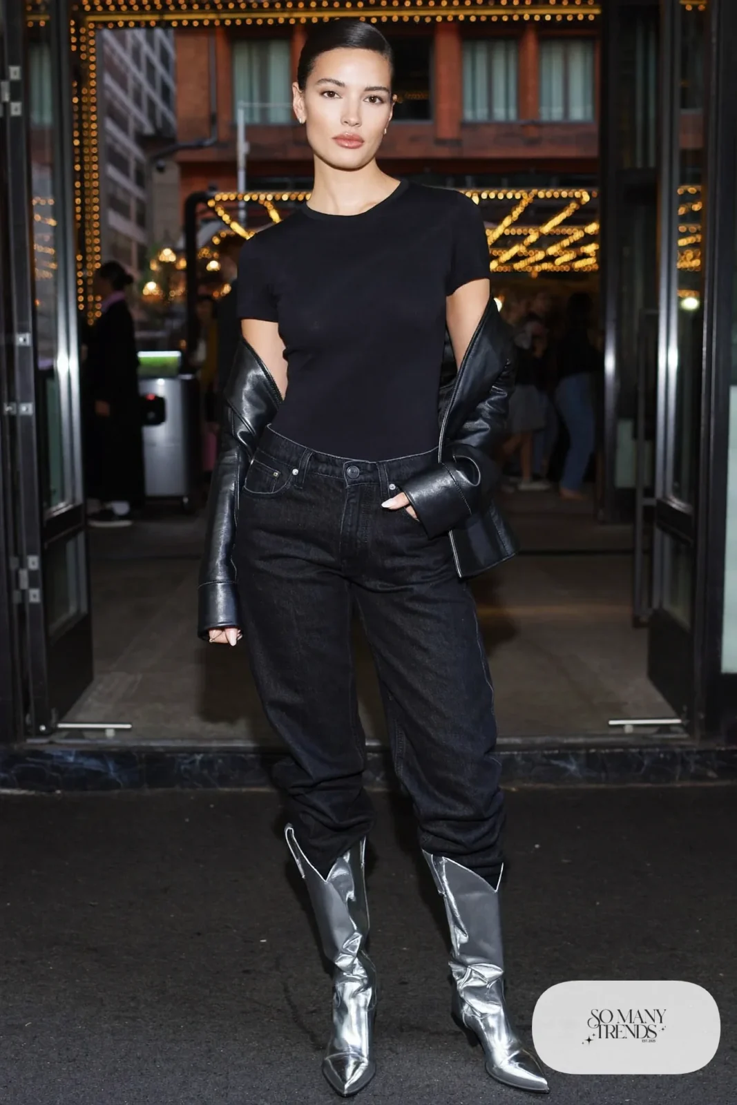 Woman in black tee, dark straight jeans, leather jacket and metallic silver cowboy boots, outfit 29