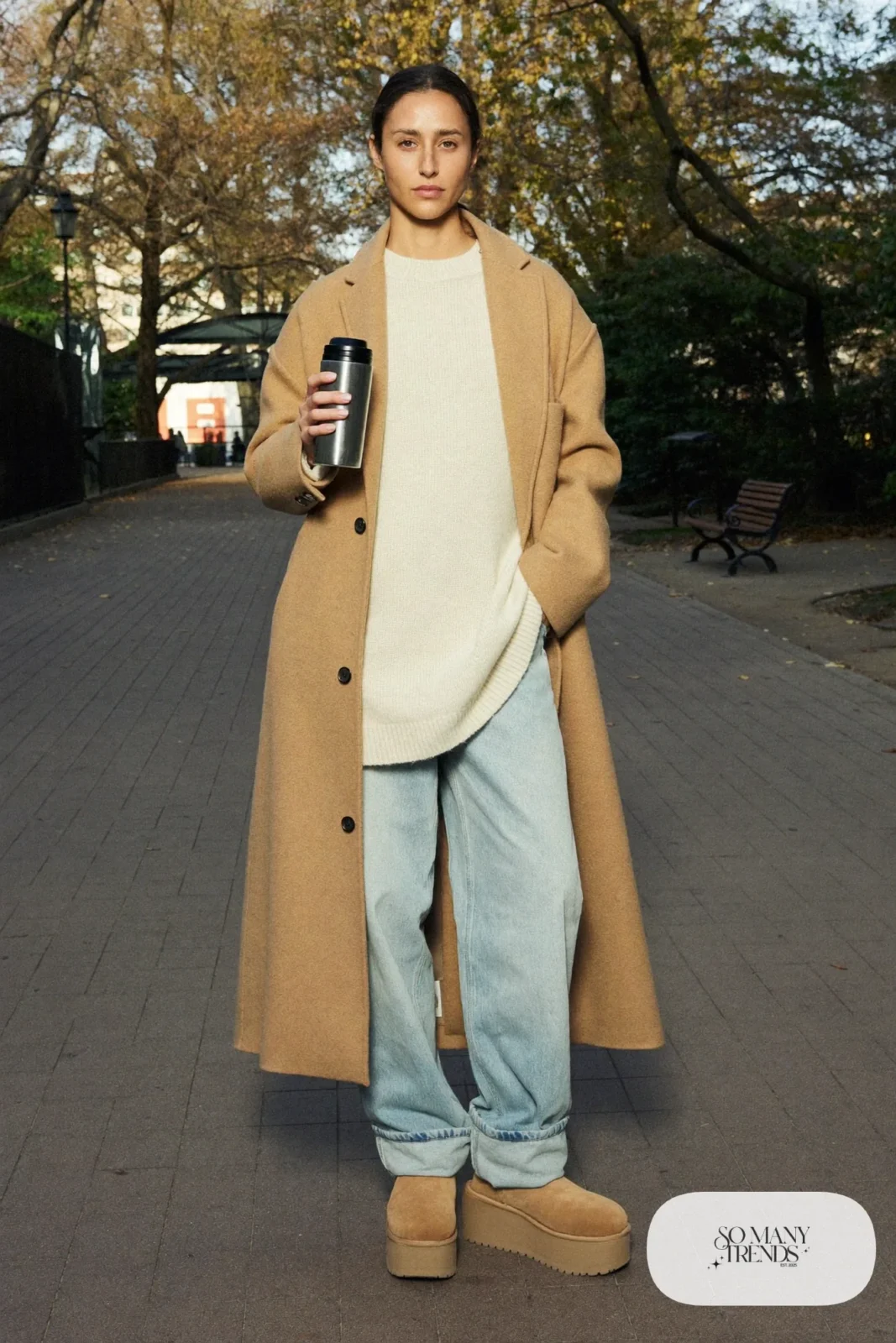 Camel wool coat, cream chunky sweater, light denim overalls and sand Ugg clogs, outfit 17