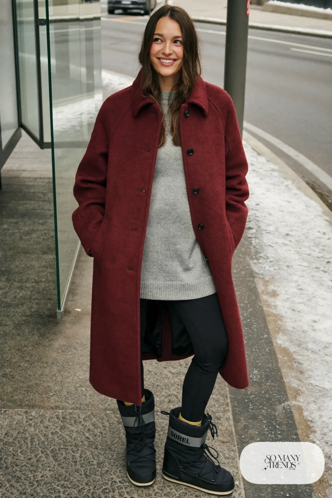 Woman in a burgundy wool coat, black leggings, gray sweater and black Sorel boots, outfit 13