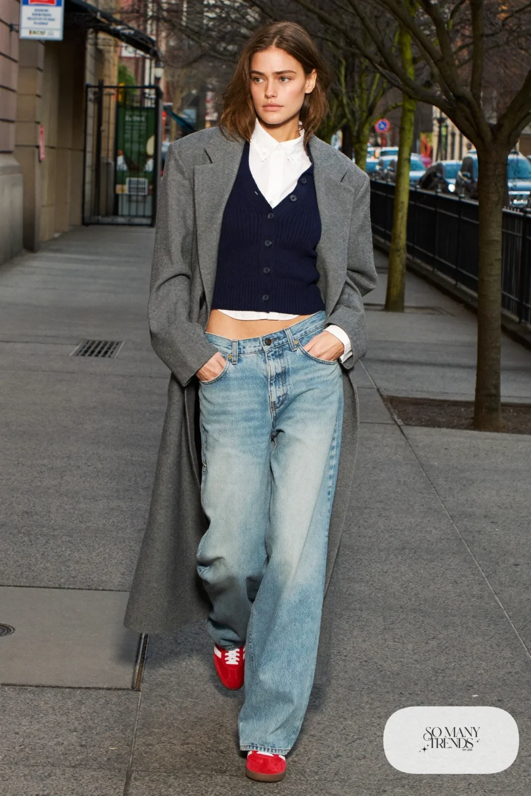 Woman in a navy knit vest over a white collared shirt, wide-leg light wash jeans and red Adidas Gazelle sneakers, outfit 3