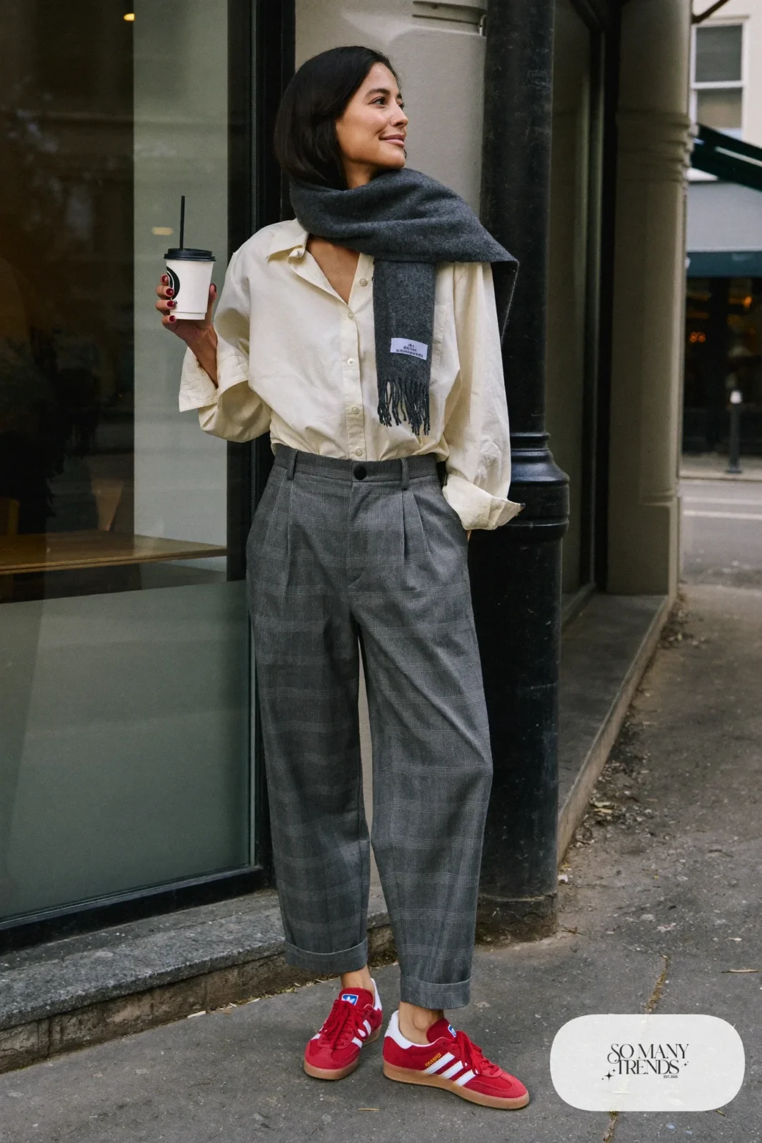 Woman in gray flannel pleated pants, cream oxford shirt, charcoal scarf and red Adidas Gazelle sneakers, outfit 8