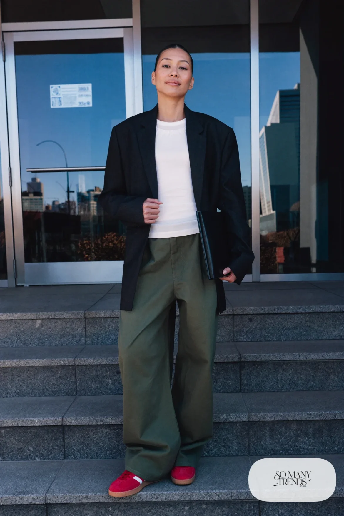 Woman in a black blazer, olive wide-leg pants, white knit top and red Adidas Gazelle sneakers, outfit 11