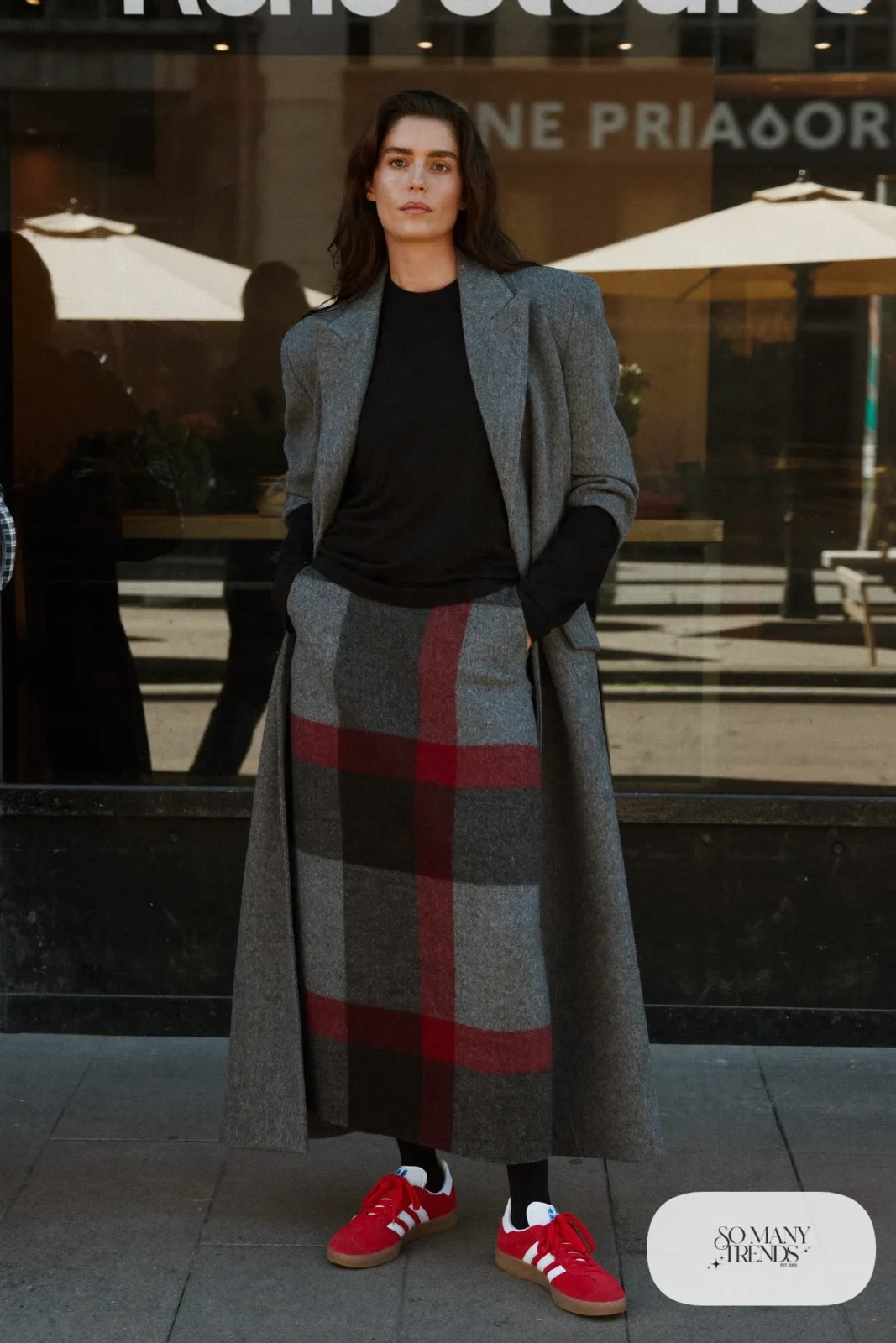 Woman in a gray plaid wool maxi skirt, fitted black sweater, black tights and red Adidas Gazelle sneakers, outfit 14