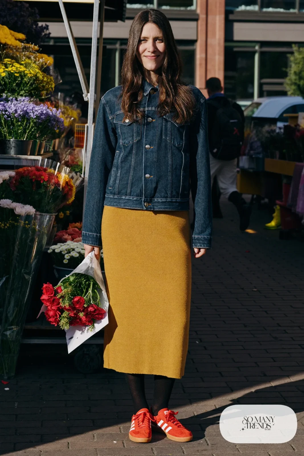 Woman in a mustard ribbed knit midi dress, dark denim jacket, black tights and red Adidas Gazelle sneakers, outfit 15