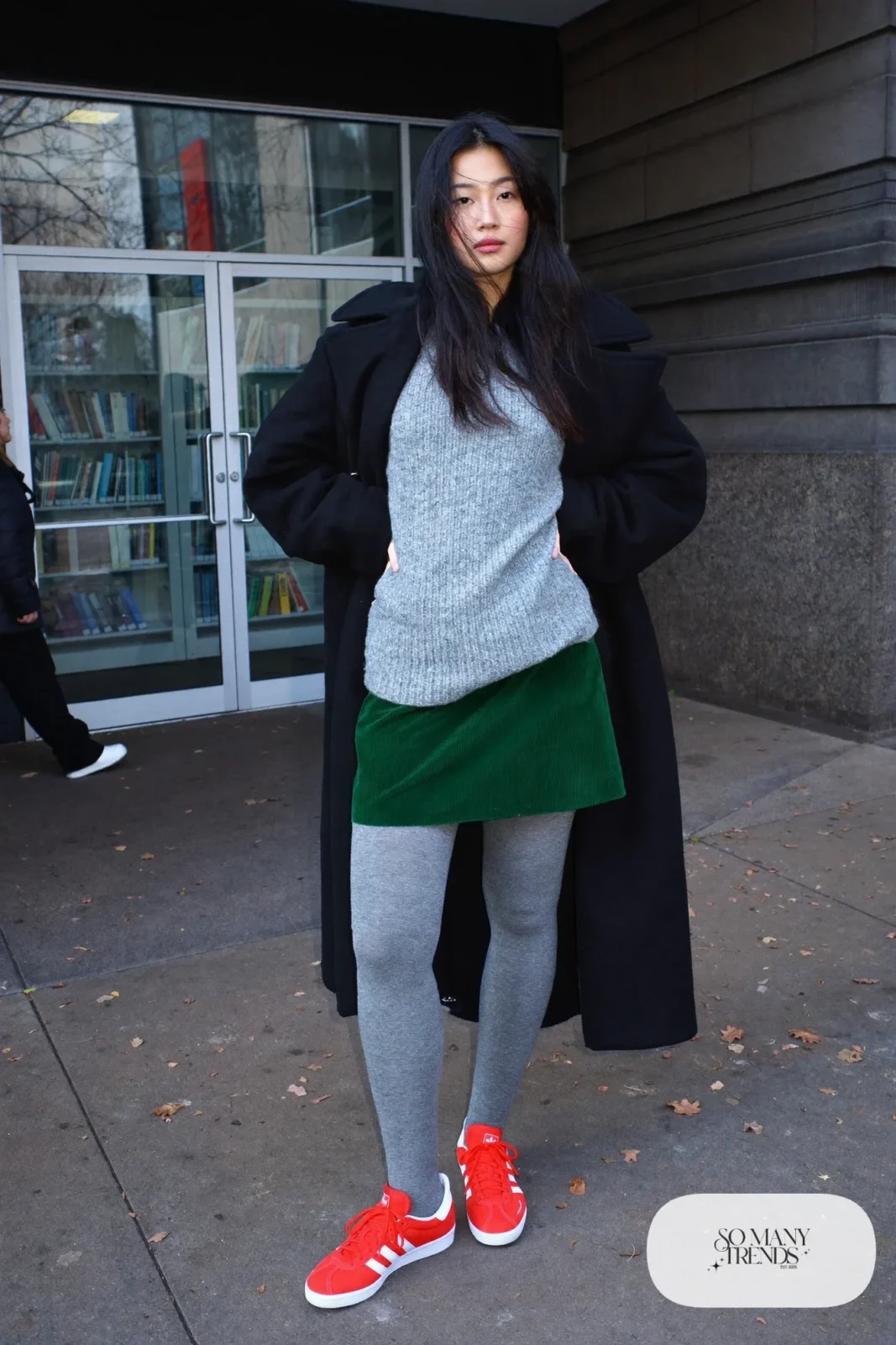 Woman in a forest green corduroy mini skirt, gray sweater, gray tights and red Adidas Gazelle sneakers, outfit 16